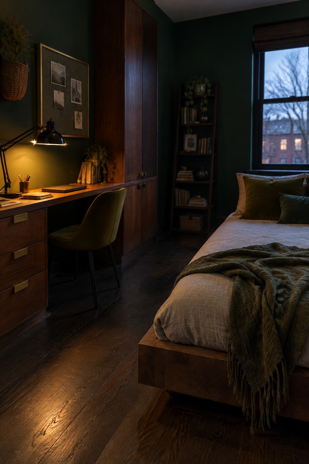 Cozy dark green bedroom with wooden desk, green velvet chair, bed, and tall bookshelf.