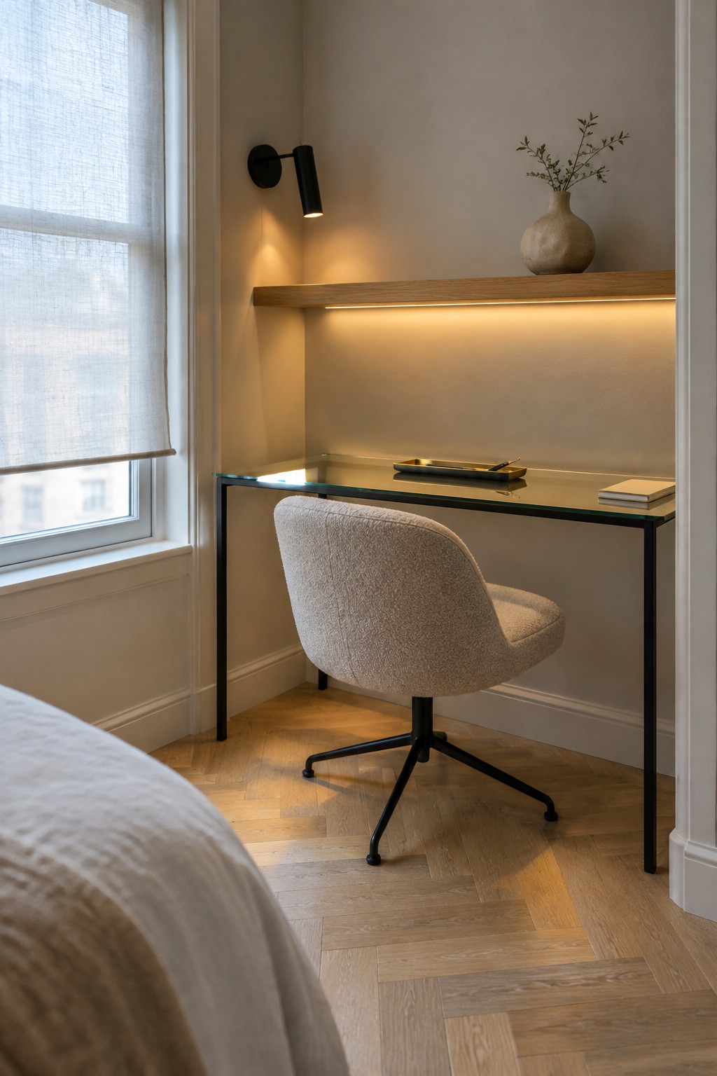 Modern glass desk with beige bouclé chair, lit wooden shelf, and black accents