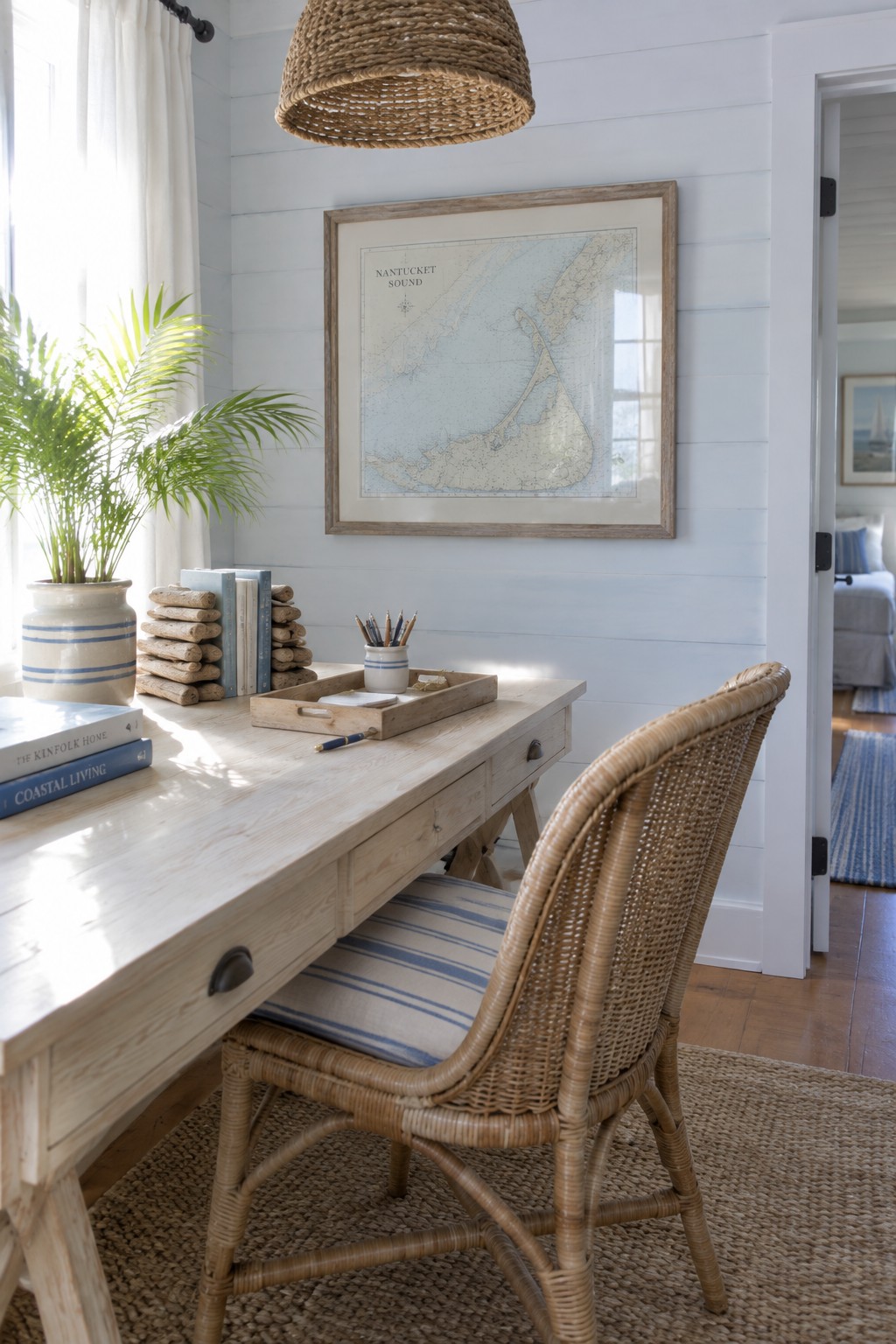 Coastal office with light wood desk, rattan chair, Nantucket map, and woven pendant light