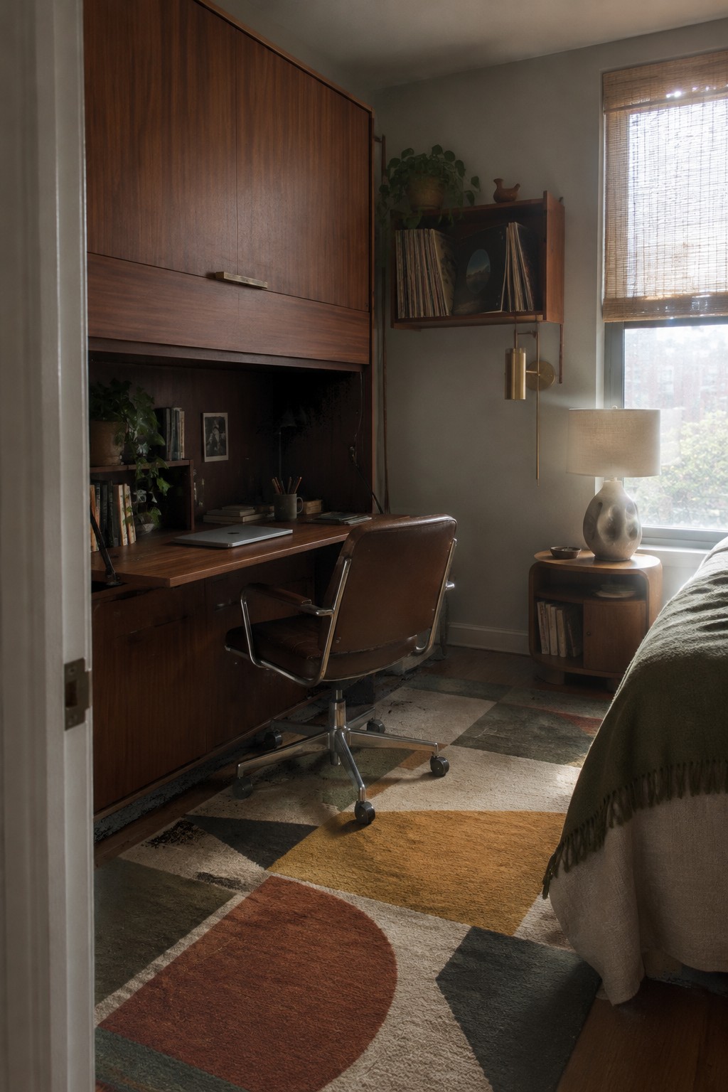 Mid-century wooden desk, brown leather chair, and colorful geometric rug in study.