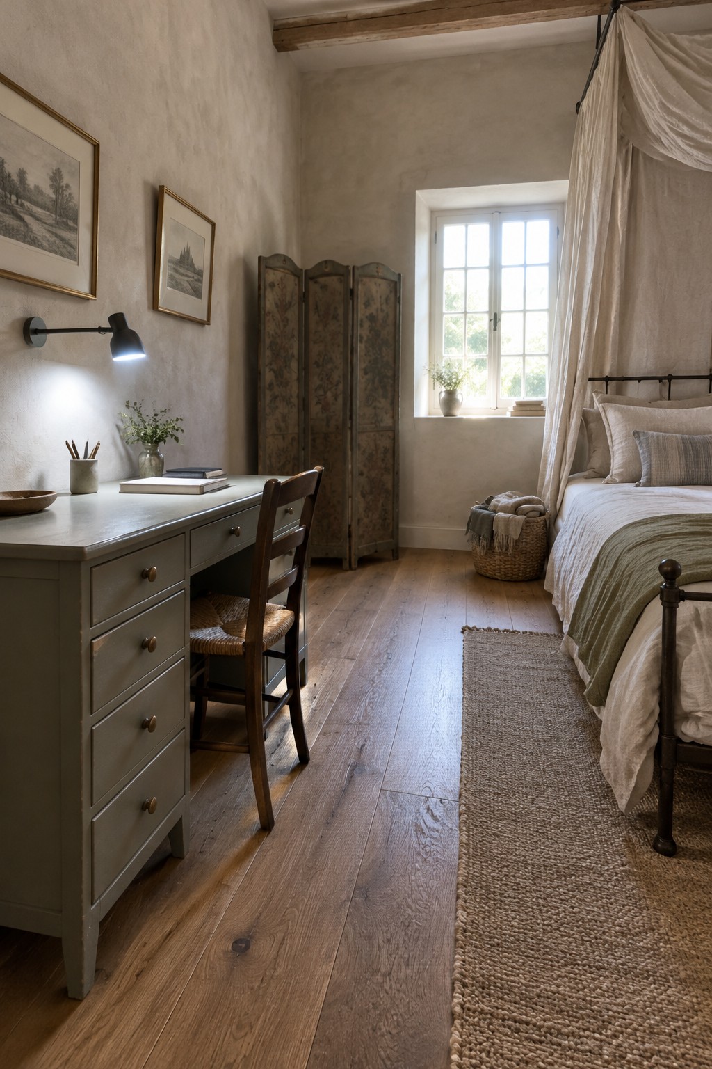 A bedroom with a gray desk against a textured wall, a black wall-mounted lamp shining on the desk, a wooden chair with woven seat, and a bed with white and green bedding on the right.